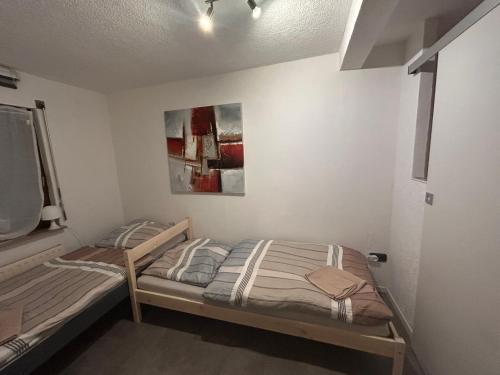 a bedroom with two beds and a painting on the wall at TIME OUT - 3 Zimmer Wohnung mitten in Plochingen in Plochingen