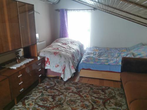 a bedroom with two beds and a dresser and a window at Willa widok na jezioro i las Swornegacie in Małe Swornigacie