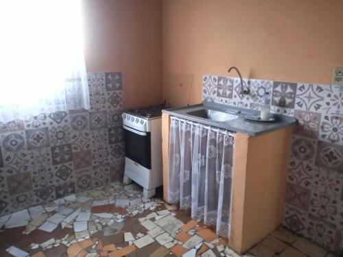 a kitchen with a sink and a stove in it at Quarto em Caraguatatuba litoral norte in Caraguatatuba
