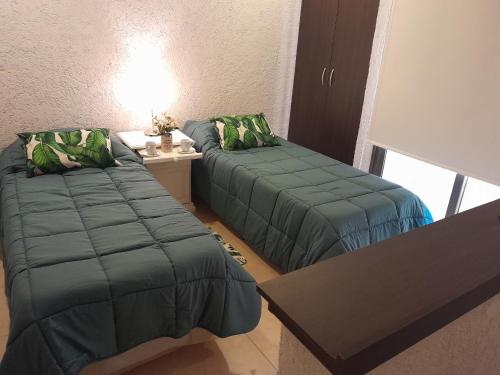 a room with two beds and a table with a lamp at Departamento Premium in Tunuyán
