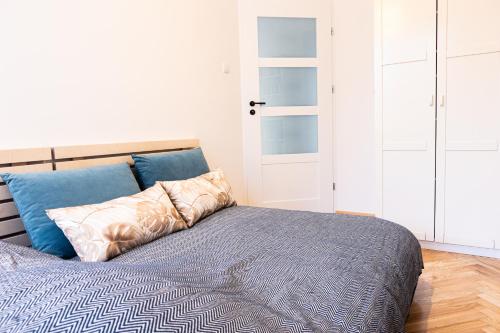 a bedroom with a bed with blue pillows at Book a book - Apartment in the city center in Warsaw