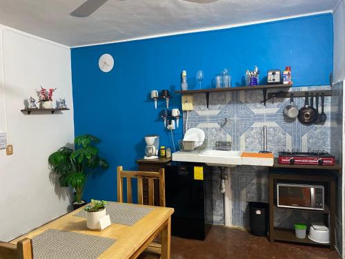 a kitchen with a table and a blue wall at PANCHITO’S in Isla Mujeres