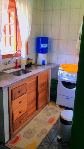 een kleine keuken met een wastafel en een fornuis bij Casa Recanto das Rosas in Monte Verde