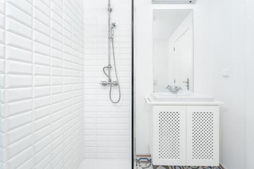 a white bathroom with a shower and a sink at Casa Pereira in Relógio do Poiso