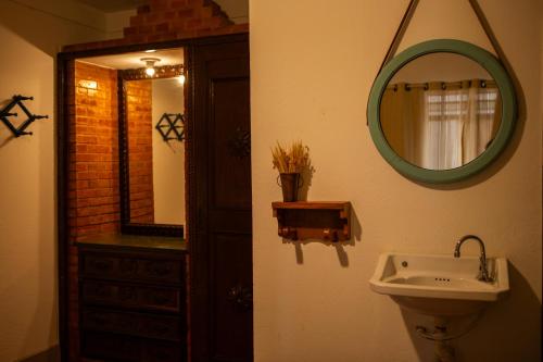 a bathroom with a sink and a mirror at Pousada do Beco in Tiradentes