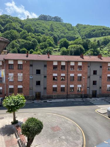 a large brick building in front of a mountain at Mountain View Apartment in Mieres