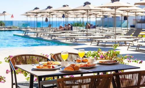a table with food and drinks next to a pool at Blue Sea Island in Kolymbia