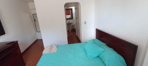 - une chambre avec un lit doté d'un oreiller bleu dans l'établissement Habitaciones doble y sencilla muy acogedoras, à Bogotá