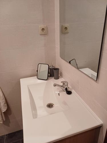 a bathroom with a white sink and a mirror at Amarante Residence in Amarante