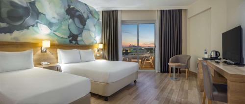 クンドゥにあるWyndham Garden Laraのベッド2台とデスクが備わるホテルルームです。