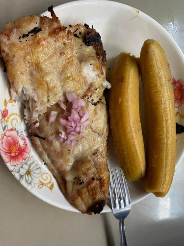 einen Teller mit einem Stück Hühnchen und einer Gurke in der Unterkunft Residencial Carloz in Tarapoto