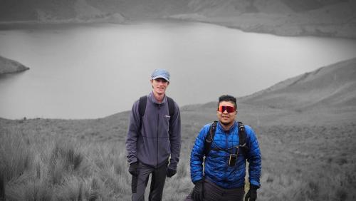 two men standing next to each other on a hill at Hostal La Rosa Otavalo in Otavalo