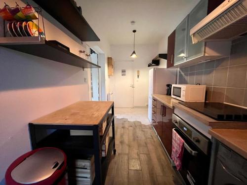 a small kitchen with a table and a microwave at Appart Proche Disneyland et Paris in Noisy-le-Grand