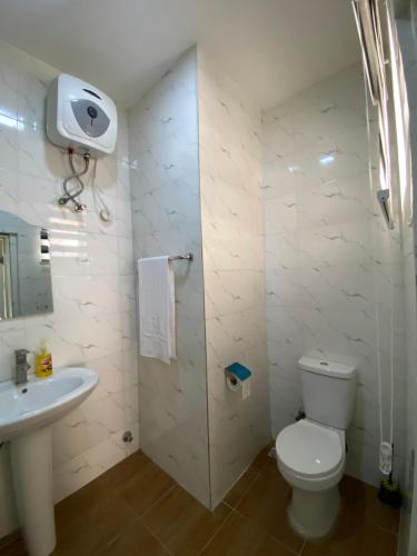 a white bathroom with a toilet and a sink at Luxury 3BR + 3.5bath apartment in Victoria Island with pool in Lagos