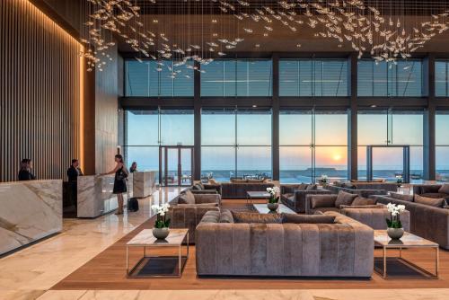 a lobby with couches and a view of the city at Cap St Georges Hotel & Resort in Peyia