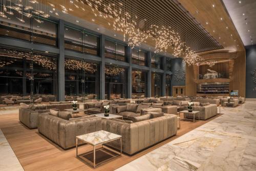 a lobby with couches and tables in a building at Cap St Georges Hotel & Resort in Peyia