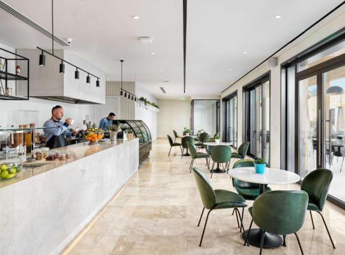 a kitchen and dining room with tables and chairs at Cap St Georges Hotel & Resort in Peyia