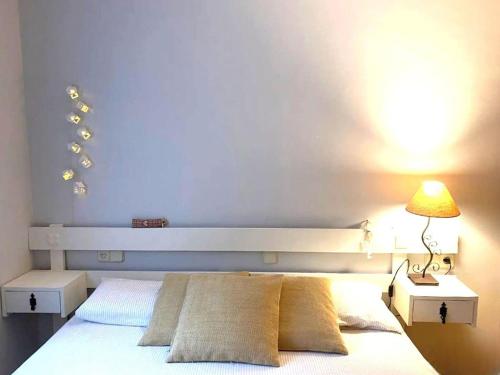 a bedroom with a white bed with a lamp on it at Rural apartment with nice views and shared pool in Montseny