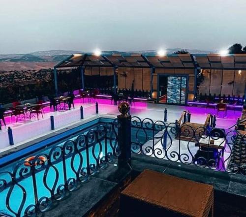 a swimming pool with purple lights on a building at مزرعة طلة الهيبة in Jal‘ad