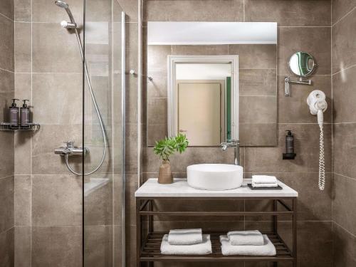 La salle de bains est pourvue d'un lavabo et d'une douche. dans l'établissement Grecotel-LUXME Costa Botanica, à Acharavi