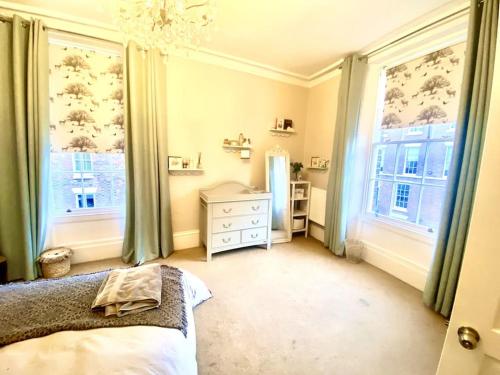 a bedroom with a bed and two large windows at Luxury Georgian Townhouse - Central Liverpool Location (Falkner St) in Liverpool