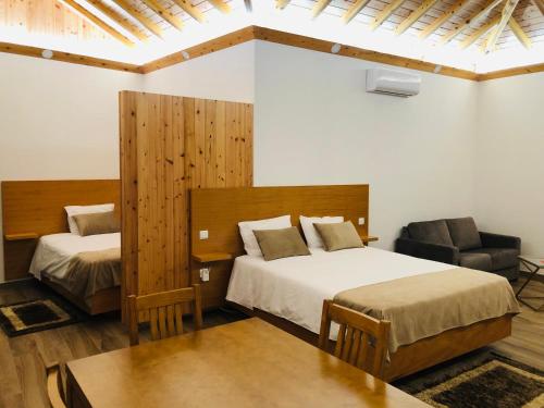 ein Hotelzimmer mit 2 Betten und einem Stuhl in der Unterkunft AMU- Apartamentos Mistérios da Urzelina in Urzelina