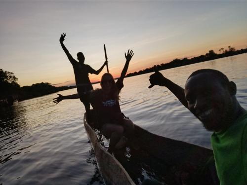 two people in a boat on the water with their arms in the air at Muke Village Guest House in Livingstone