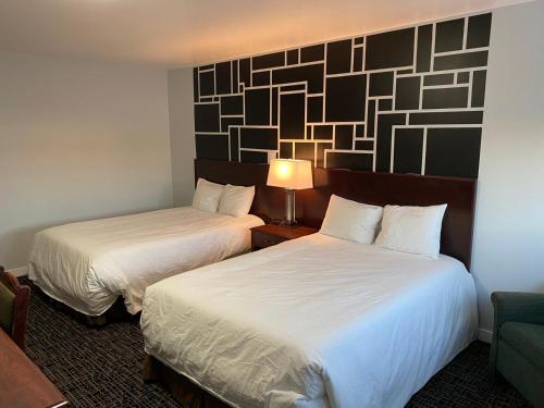 a hotel room with two beds and a lamp at Bavarian Inn in Bruce Mines