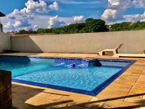 アチバイアにあるCasa de Temporada Magnífica com piscinaの犬のスイミングプールでの水泳
