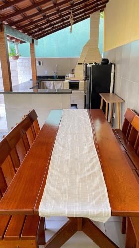 a kitchen with a wooden table with chairs and a kitchen with a stove at Espaço Zoey in Búzios