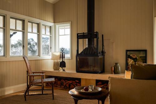 a living room with a stove and a chair at The Homestead at Ballandean Lodge in Ballandean