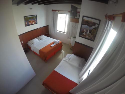 een kleine slaapkamer met 2 bedden en een raam bij CASA HOSPEDAJE SEA LIONS in Puerto Villamil