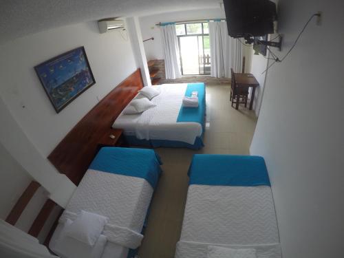 een slaapkamer met 2 bedden aan de bovenkant bij CASA HOSPEDAJE SEA LIONS in Puerto Villamil