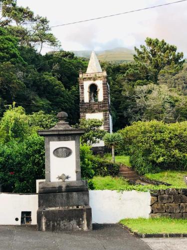 a small monument in front of a small tower at AMU- Apartamentos Mistérios da Urzelina in Urzelina