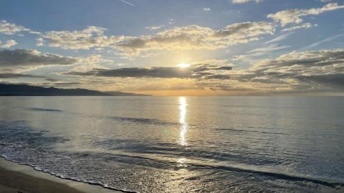 a sunset on the beach with the sun setting at Mari'Entu in Quartu SantʼElena