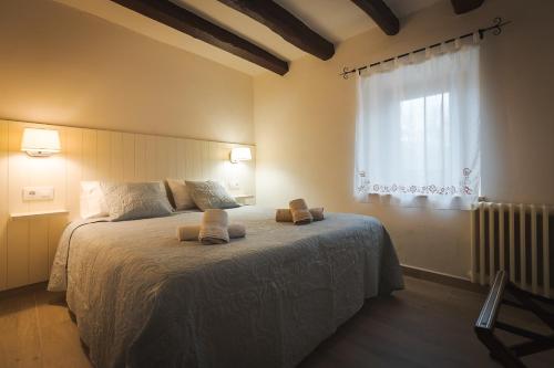 a bedroom with a bed with two towels on it at Mas Riera - 2 in Maia de Montcal