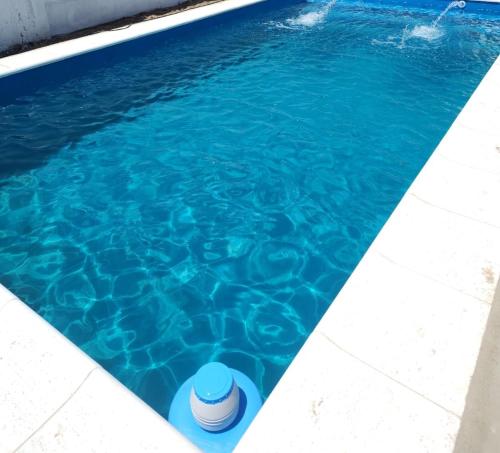 uma piscina com água azul e um barril em C & J Casa de alquiler em Maco