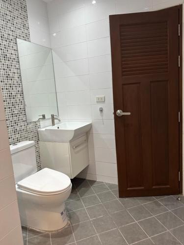 a bathroom with a toilet and a sink and a mirror at 2 Bedroom Seaview Apartment Lanta Sport Resort 305 in Phra Ae beach