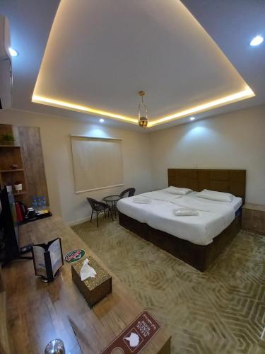 um quarto com uma cama grande e uma mesa em دايموند Diamond em Al-ʿUla