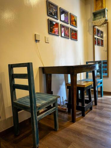 un banco de madera, una mesa de madera y una silla en Seth Room, en Baguio