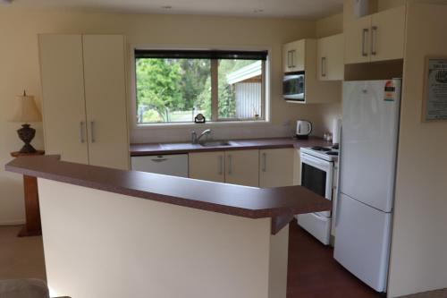 uma cozinha com electrodomésticos brancos e uma bancada em Jennifer's Cottage 