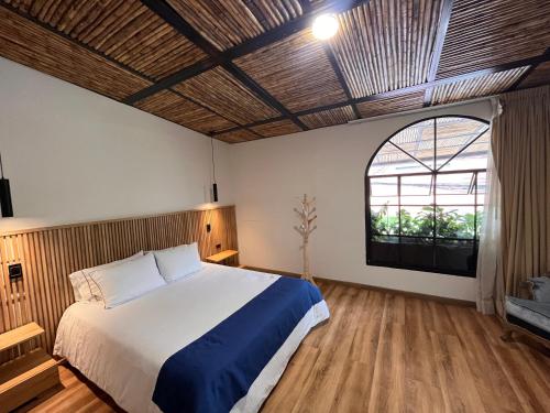 a bedroom with a bed and a large window at Pepe's House Usaquén I Cozy Hotel in Bogotá