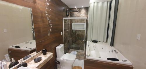 a bathroom with a toilet and a shower and a sink at CASA NA BARRA DE SANTO ANTONIO in Barra de Santo Antônio