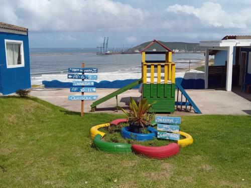 - une aire de jeux avec des panneaux de rue en face d'une plage dans l'établissement Hospedaria Mirante da maré ap4, à Imbituba