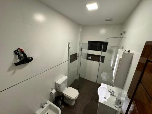 a white bathroom with a toilet and a shower at Apart hotel JJ - a estrenar in Paso de los Libres