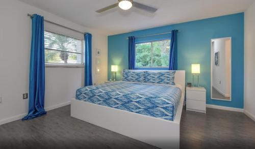 Schlafzimmer mit einem Bett mit blauen Wänden und einem Fenster in der Unterkunft Contemporary Cozy Pool Villa II - Pool & Nearby Beach in Venice