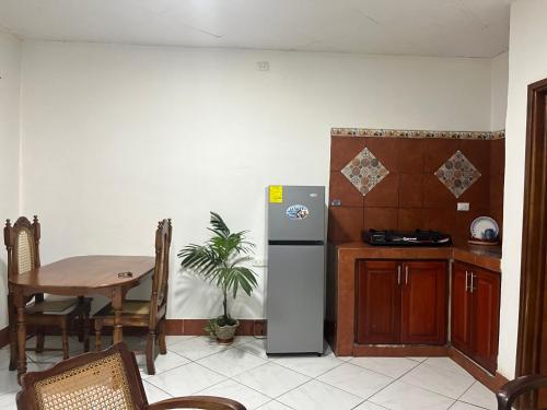 a kitchen with a table and a refrigerator in a room at Apartamento Los Monges in León