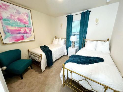 a bedroom with two beds and a green chair at Orange Park Townhome Vacation Rental with Patio! in Orange Park