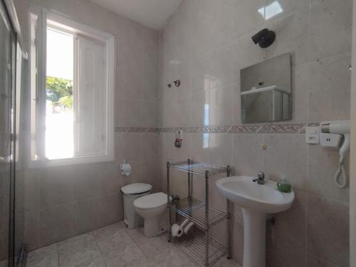 uma casa de banho com um lavatório, um WC e um espelho. em Casa das Luzes Hostel IVN no Rio de Janeiro