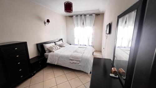 1 dormitorio con cama blanca y ventana en Magnifique Appartement spacieux confort propre ,familial 2 chambres, salon salle à manger, 20mn a pied place jemaa el fina ,p3, en Marrakech